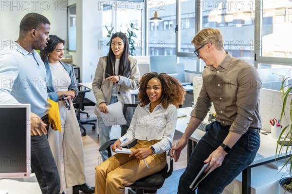 Diverse colleagues engaging in teamwork, sharing ideas, and working together in a modern coworking