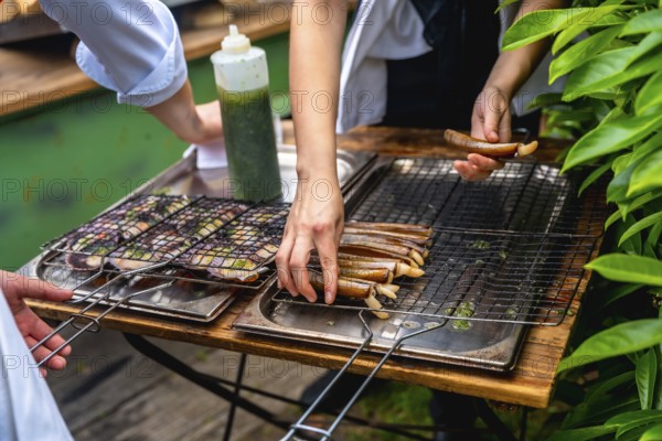 Chefs grilling seafood in an outdoor setting, preparing dishes for a wedding reception, with fresh