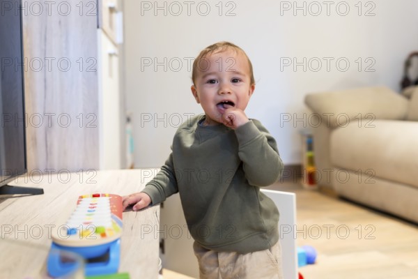 Curious toddler engaging with colorful musical toy, exploring sounds and developing musicality in a