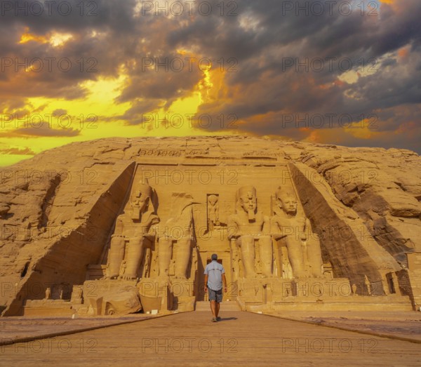 A young man walking towards the Abu Simbel Temple in southern Egypt in Nubia next to Lake Nasser.