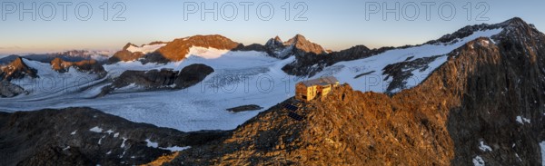 Atmospheric sunrise in a picturesque mountain landscape, alpenglow, aerial view, mountain hut