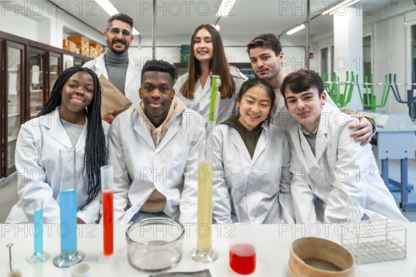 Group of diverse university students and their teacher posing together in a chemistry laboratory,