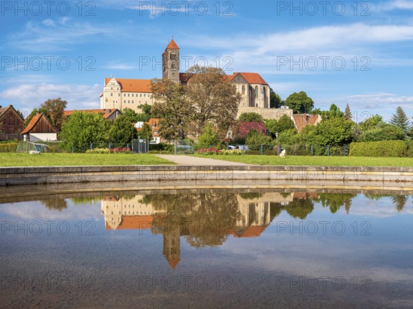 Castle hill with collegiate church of St. Servatius with reflection in water basin in autumn,