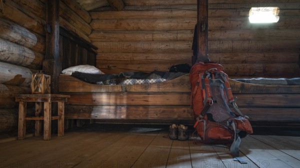 Rustic interior of a wooden hut with small beds and a rucksack and hiking boots, Olavsweg or
