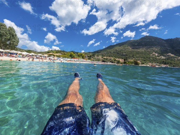 A man resting in the sea on the beach in summer of Paralia Mikros Gialos in the south of the island