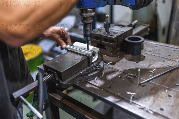 Close-up of male worker working using threading machine in cnc metal workshop