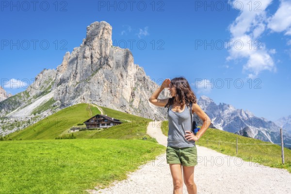 Female hiker walking along a mountain path, soaking in the breathtaking views of the dolomites