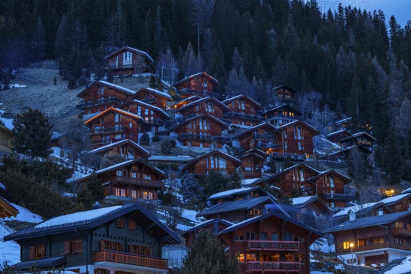 Chalets built into the hillside as holiday homes at dusk, Grimentz, Val d'Anniviers, Valais Alps,