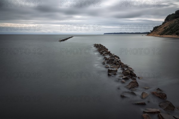 Coastal protection made of boulders, coastline on the Baltic Sea, dusk, long exposure, Baltic Sea