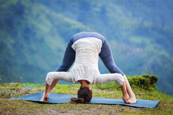 Yoga exercise outdoors, woman doing Ashtanga Vinyasa Yoga asana Prasarita padottanasana D, wide