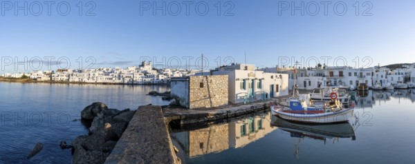 Panorama, view of the town of Naoussa and blue sea, harbour with fishing boats and reflection,