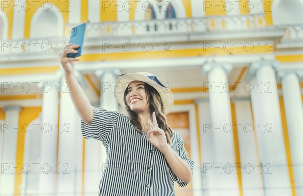 Young tourist woman with hat taking selfie in a square. Selfies and vacation concept. Beautiful