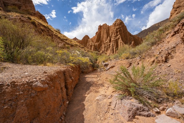 Eroded mountain landscape with sandstone cliffs, canyon with red and orange rock formations,