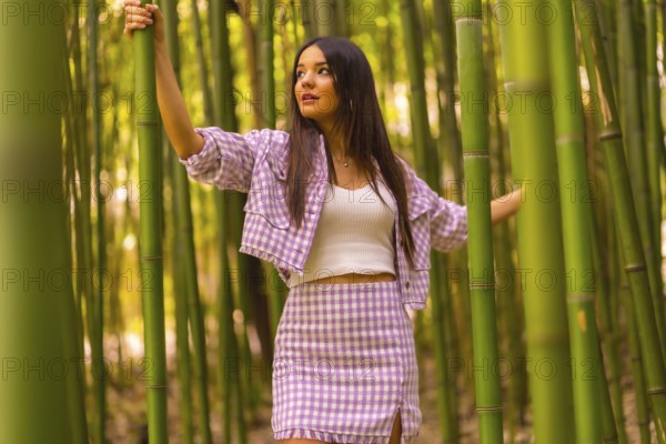 Young caucasian girl with a pink skirt in a bamboo forest. Enjoying the city on summer holidays in