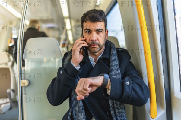 Frontal portrait of a serious caucasian adult, businessman using smartwatch while talking to the