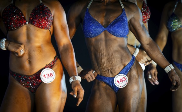 Female bodybuilders pose on stage as they compete the 4th Ms Saraighat all India classic body