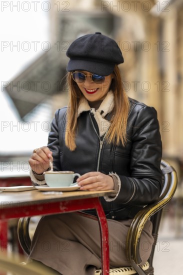 Tourist savoring a cappuccino at an outdoor cafe in bordeaux, france, enjoying the charming