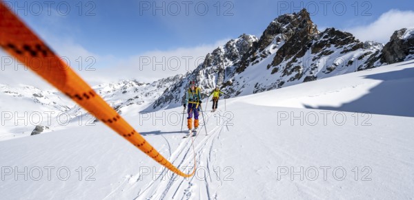 Ski tourer with rope, rope team on the Vadret da Porchabella glacier on the ascent to the summit of
