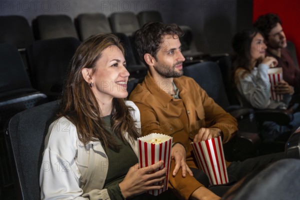 Group of friends enjoying a movie at the cinema, sharing laughter and popcorn while soaking in the