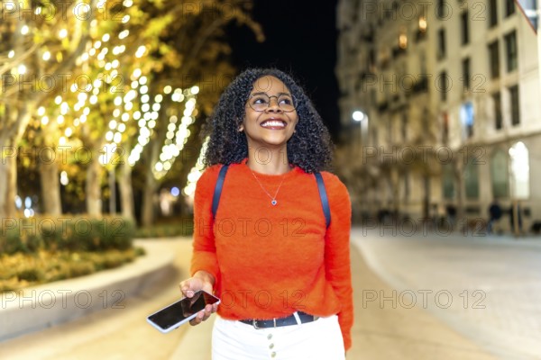 Young woman enjoying an evening stroll through a vibrant, illuminated city, engaging with her