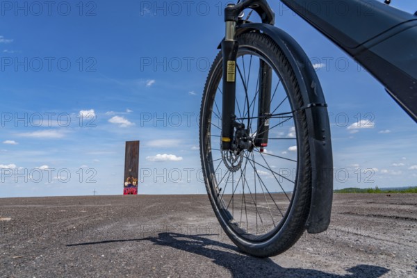 Cycling in the Ruhr area, on the Schurenbach slag heap, Bramme landmark for the Ruhr area by artist