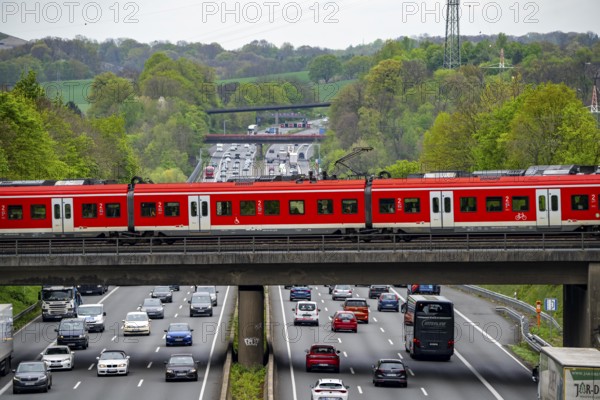 S-Bahn train crossing the motorway A3, traffic on 8 lanes, incl. the temporarily released hard