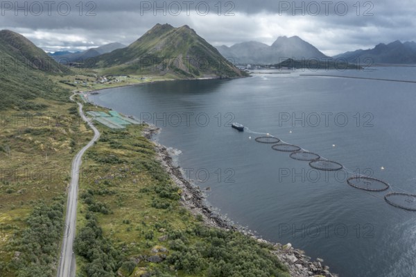Aerial view of a salmon farm, rainy weather, grey sky, village Myre in the back, Vesteralen