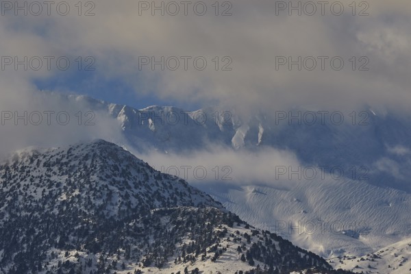 Snow-covered mountain peaks under a slightly cloudy sky, Lefka Ori, White Mountains, mountain