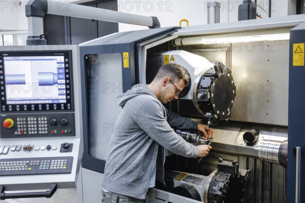 Remscheid, North Rhine-Westphalia, Germany - Trainee in metalworking, here at a CNC machine tool,