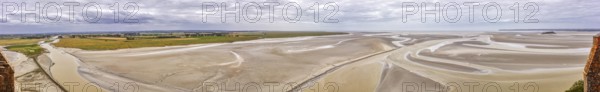 Expansive panorama with sand, watercourses and a wide horizon under a cloudy sky, Le