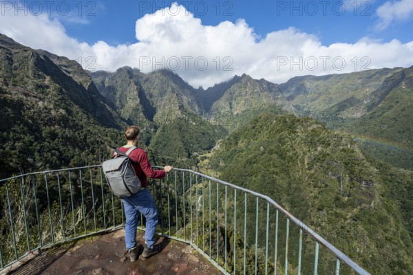 Tourist at a viewpoint, view from the Miradouro dos Balcões, densely overgrown steep mountains,