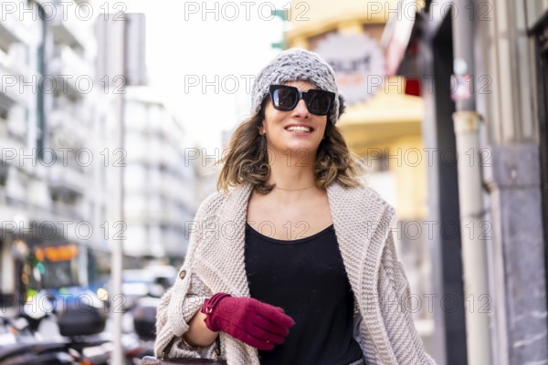 Lifestyle, young Caucasian blonde girl enjoying and smiling in the city in winter. Strolling with