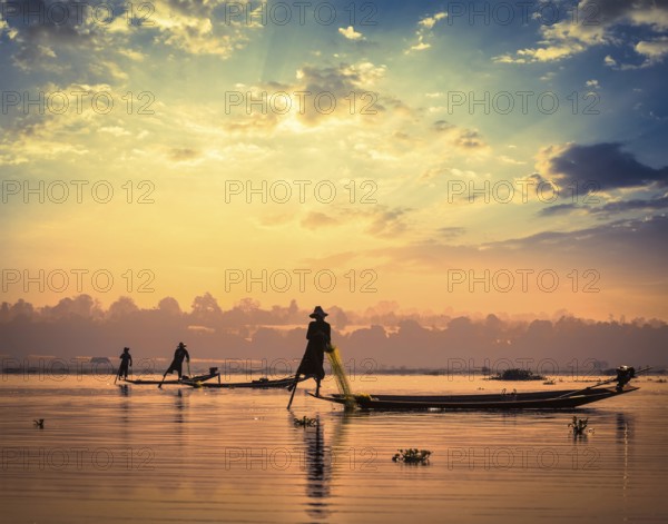 Myanmar travel attraction landmark, traditional Burmese fishermen sihouettes at Inle lake on