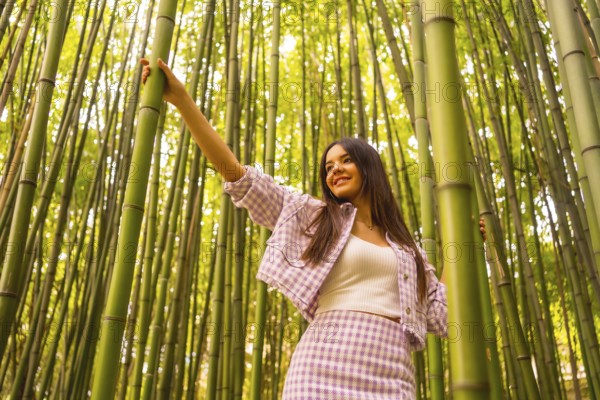 Young caucasian girl with a pink skirt in a bamboo forest. Enjoying the summer holidays in a
