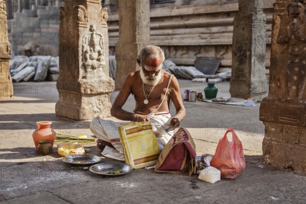 MADURAI, INDIA, FEBRUARY 16, 2013: Indian brahmin (traditional Hindu society) priest with donation