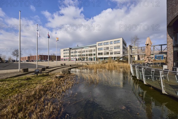 Rathausterassen Garbsen, outdoor area of a restaurant, pond, lawn, flagpoles, commercial buildings,