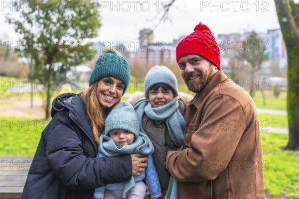 Smiling family bundled in warm winter clothes, enjoying a cheerful day outdoors in a city park,