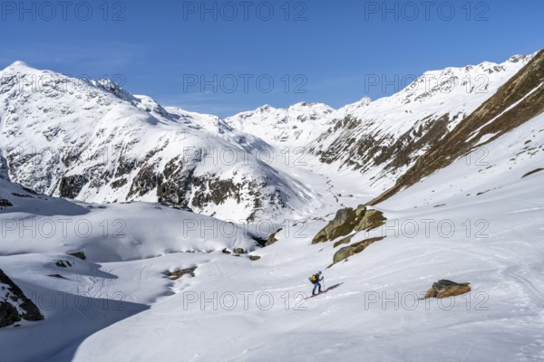 Acitourers climbing up to the Grialetsch Scharte, view of the Funtauna Valley in winter, Graubünden