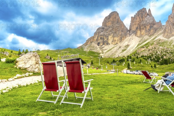Red deckchairs inviting tourists to relax and enjoy the breathtaking view of the sassolungo