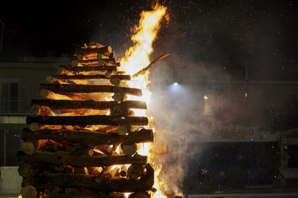 A large pile of wood burns brightly and is surrounded by flames, Easter bonfire Psinthos, Holy