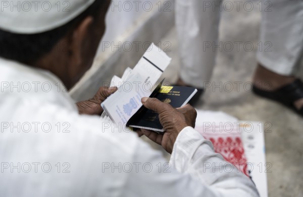 Hajj pilgrims check passport and documents before leaving to the airport, in Guwahati, India on 3