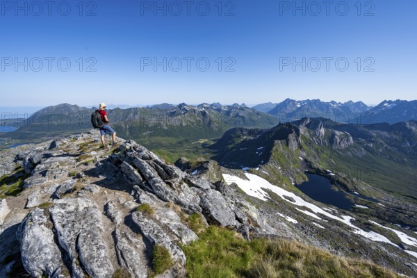 View of mountains and fjord landscape, mountaineers at the summit of Rundfjellet, Lake