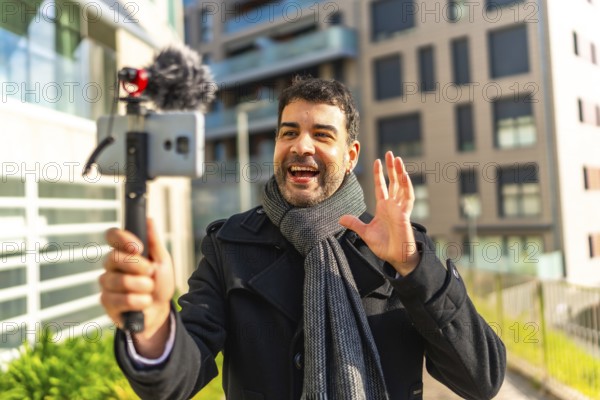 Male caucasian elegant mature vlogger waving while explaining something to the audience streaming