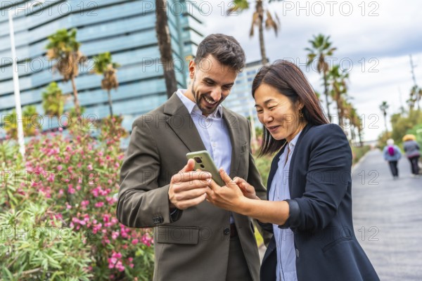 Happy multi-ethnic business people using mobile and smile standing in a financial district in a