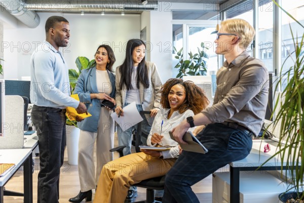 Diverse colleagues interacting, sharing ideas, and working together in a bright, open plan office