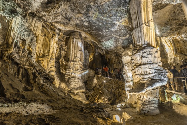 Tourists admiring giant stalactites and stalagmites inside the famous postojna cave, a major