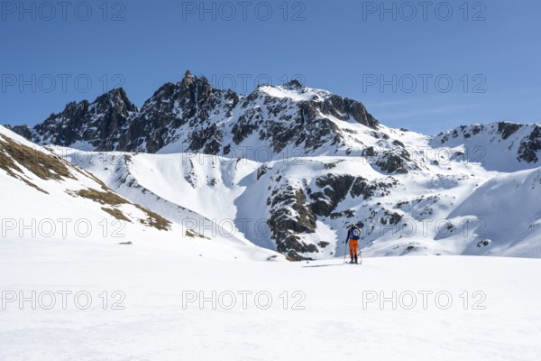 Ski tourers on the Graubünden Haute Route in the Val Susauna mountain valley, snow-covered
