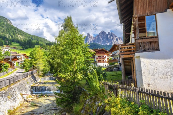 Scenic summer view of santa maddalena village with the odle mountains reflecting in the funes