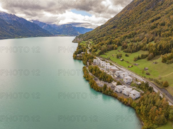 Lake with neighbouring buildings on the mountain slopes under a cloud cover, Lake Brienz.