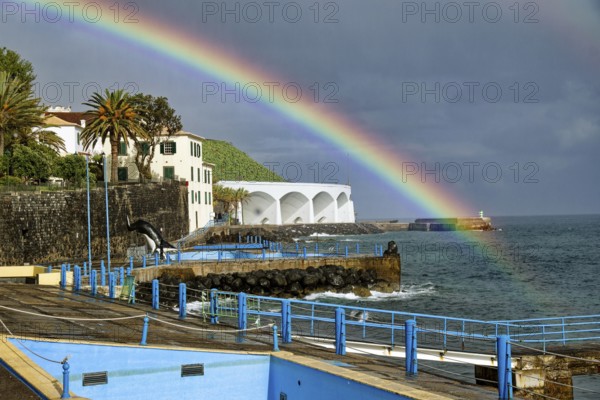 Promenade in rainy weather with rainbow on the beach of the Atlantic Ocean, municipality of Santa